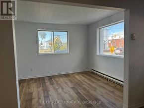 Casselman apartment for rent - A room with a window showing a view of a street with cars and buildings.