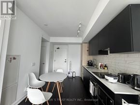 Toronto (Waterfront Communities) condo for rent - A kitchen with a table and chairs in the middle of it.