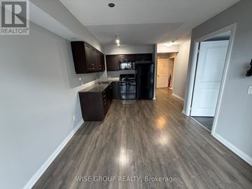 Toronto (Woburn) condo for rent - A kitchen with dark wood cabinets and a black dishwasher.