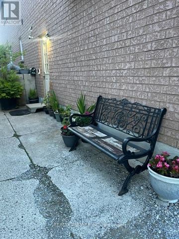 Vaughan (Maple) apartment for rent - A black bench with a potted plant on the ground.