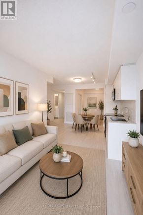 Toronto (Humber Heights) condo for rent - A modern living room with a white couch, a coffee table, and a kitchen area in the background.