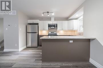 Hamilton (Eastmount) triplex for rent - A kitchen with white cabinets and a stainless steel refrigerator.