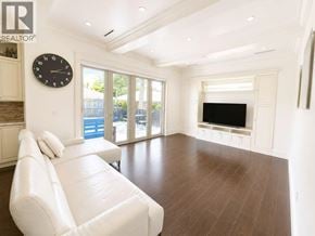 Vancouver apartment for rent - A living room with a white couch and a black clock on the wall.