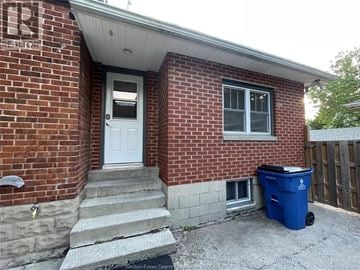 Chatham apartment for rent - A red brick house with a white door and a blue trash bin.