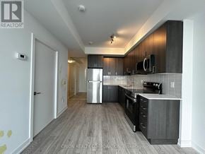 Pickering (Bay Ridges) condo for rent - A modern kitchen with dark wood floors and stainless steel appliances.