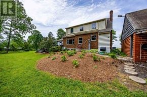 Norfolk multi-family for rent - A house with a well-maintained lawn and a mulched garden bed in front.