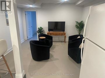 Norfolk multi-family for rent - A living room with a black chair and a television.