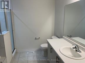 Centre Wellington (Fergus) apartment for rent - A bathroom with a toilet, sink, and mirror.