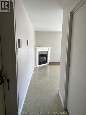 Amherstburg apartment for rent - A hallway with a door on the left and a fireplace in the distance.