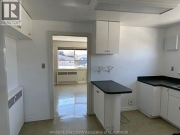Amherstburg apartment for rent - A kitchen with white cabinets and a black countertop.