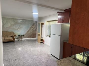 Surrey apartment for rent - A kitchen with a white refrigerator and brown cabinets.