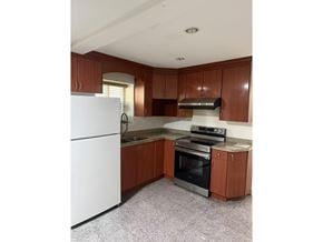 Surrey apartment for rent - A kitchen with a white fridge and wooden cabinets.