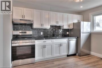 Kitchener apartment for rent - A modern kitchen with white cabinets and stainless steel appliances.