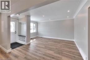 Kitchener apartment for rent - A spacious room with wooden flooring and white walls.