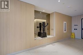 Mississauga (Mississauga Valleys) condo for rent - A hallway with a statue in the middle and a RE/MAX Atrium Home Realty sign on the wall.