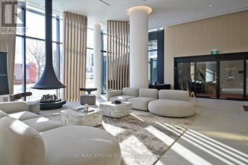 Mississauga (Mississauga Valleys) condo for rent - A modern living room with white furniture and a large window.