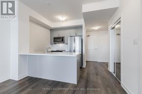 Hamilton (Waterdown) condo for rent - A kitchen with a refrigerator, microwave, and sink.