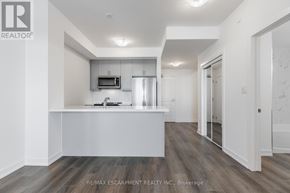 Hamilton (Waterdown) condo for rent - A modern kitchen with white cabinets and a wooden floor.