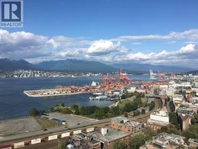 Vancouver apartment for rent - A cityscape with a large body of water and mountains in the distance.