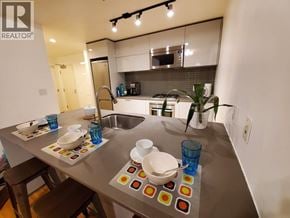 Vancouver apartment for rent - A modern kitchen with a stainless steel island and bar stools.