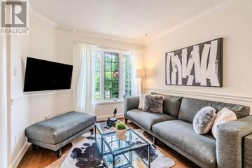 Mississauga (Lisgar) apartment for rent - A living room with a grey couch, a black flat screen TV, and a large abstract painting on the wall.
