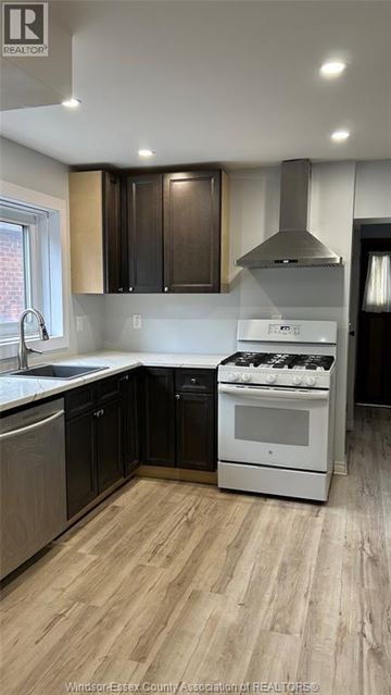 Windsor apartment for rent - A kitchen with a white stove top oven and black cabinets.