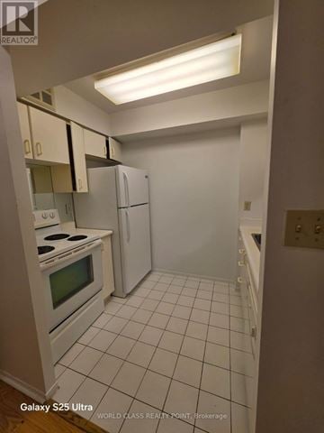 Mississauga (City Centre) condo for rent - A kitchen with white appliances and cabinets.