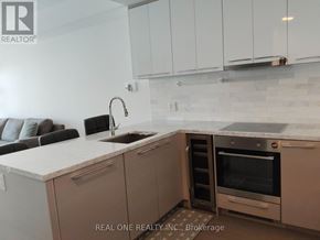 Toronto (University) condo for rent - A modern kitchen with a sink, oven, and cabinets.