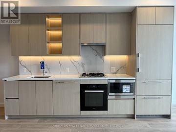 Toronto (Bayview Village) condo for rent - A modern kitchen with a marble countertop and stainless steel appliances.