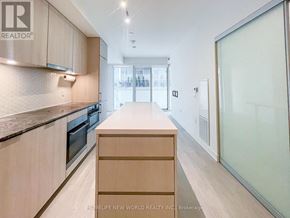 Toronto (Waterfront Communities) condo for rent - A modern kitchen with wooden cabinets and a countertop.