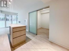 Toronto (Waterfront Communities) condo for rent - A room with a wooden dresser and a sliding glass door.