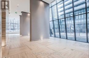 Toronto (Church-Yonge Corridor) condo for rent - A spacious office lobby with a large glass wall and wooden flooring.