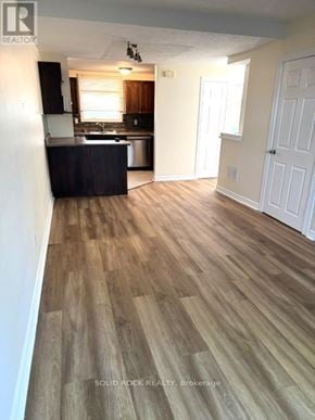 Ottawa townhouse for rent - A room with wooden flooring and a kitchen area in the background.