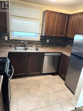 Ottawa townhouse for rent - A kitchen with brown cabinets and a black stove top oven.