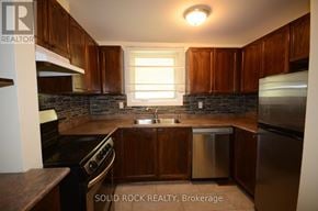 Ottawa townhouse for rent - A kitchen with brown cabinets and stainless steel appliances.