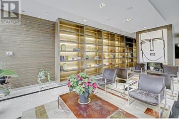 Toronto (Bay Street Corridor) condo for rent - A living room with a large bookshelf and a drawing of a face on the wall.