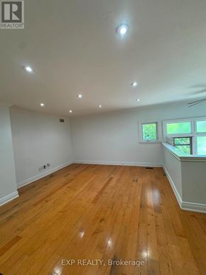 Oakville (Wo West) apartment for rent - A room with wooden flooring and a window with a view of greenery outside.