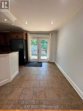 Oakville (Wo West) apartment for rent - A kitchen area with a black fridge and a doorway leading outside.