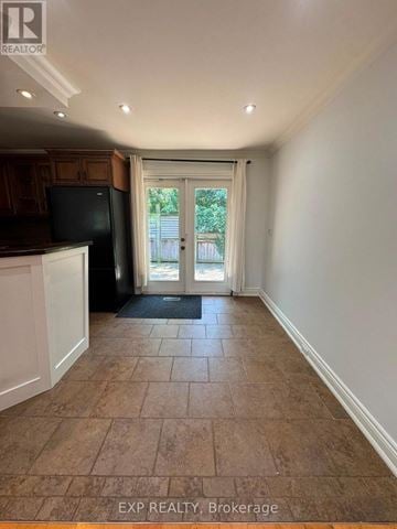 Oakville (Wo West) apartment for rent - A kitchen area with a black fridge and a doorway leading outside.