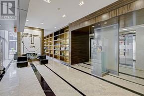Toronto (Bay Street Corridor) condo for rent - A modern office lobby with a glass wall and a black and white striped floor.