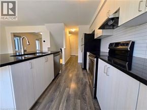 Cambridge townhouse for rent - A modern kitchen with white cabinets and black countertops.