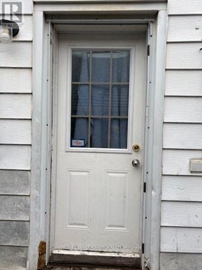 Welland (Welland Downtown) triplex for rent - A white door with a glass window and a gold handle.