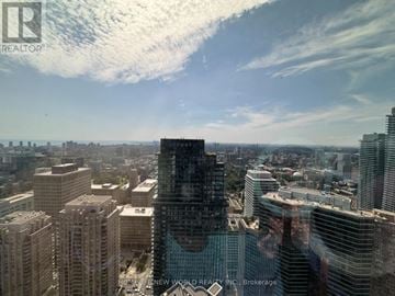 Toronto (Bay Street Corridor) condo for rent - A cityscape with a large building in the foreground and a clear sky above.