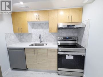 Toronto (Greenwood-Coxwell) apartment for rent - A kitchen with wooden cabinets and a stainless steel dishwasher.