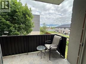 Chatham condo for rent - A balcony with a table and two chairs overlooks a grassy area.