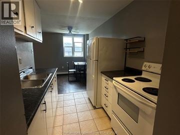 Chatham condo for rent - A kitchen with white appliances and black countertops.