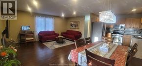 Windsor apartment for rent - A living room with a red couch and a dining table with chairs.