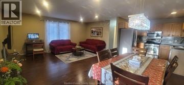 Windsor apartment for rent - A living room with a red couch and a dining table with chairs.