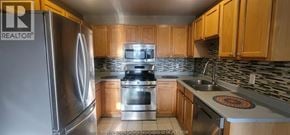 Windsor apartment for rent - A kitchen with wooden cabinets and a stainless steel refrigerator.