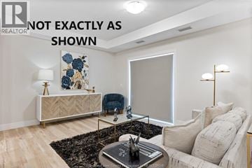 Kingsville condo for rent - A living room with a white sofa, a coffee table, and a large painting on the wall.